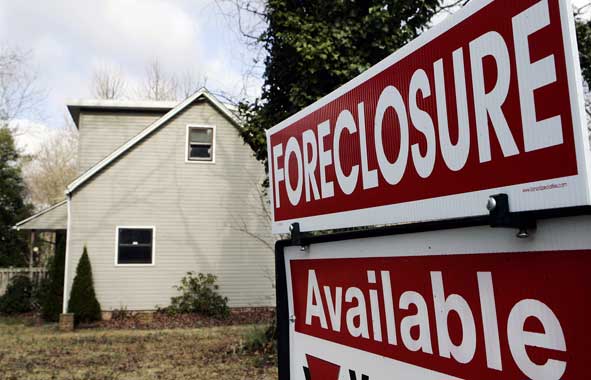 forclosure sale sign in yard of tan house